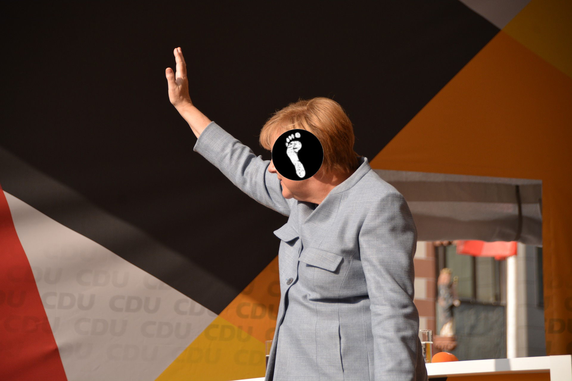 Logo vor winkender Angela Merkel