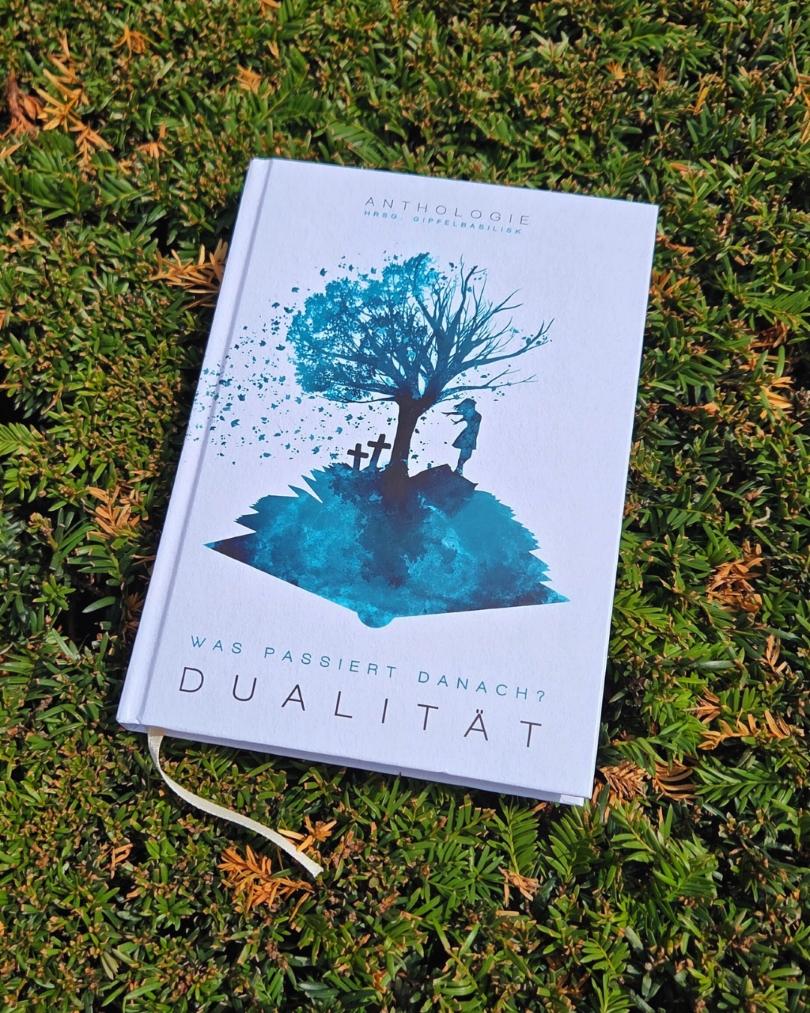 Buch "Was passiert danach? Dualität" liegt auf grünen Nadelzweigen